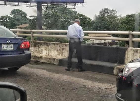 man-urinating-on-a-bridge-in-lagos