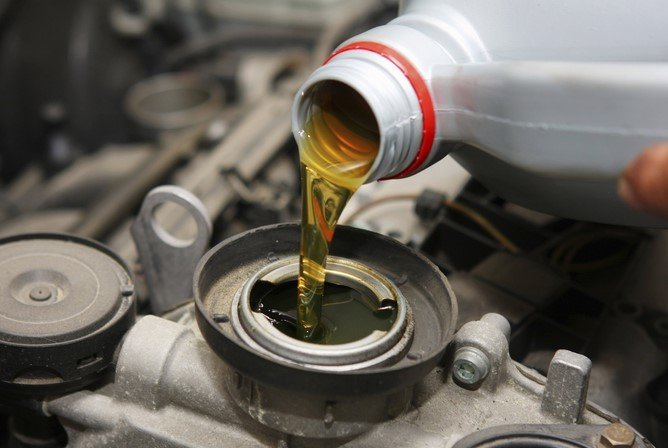 engine oil being poured into a car engine