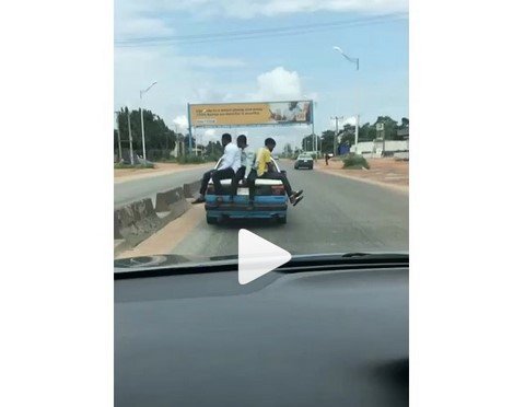 3 young boys sitting on a moving car