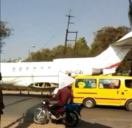 private jet being towed by tractor on a major road