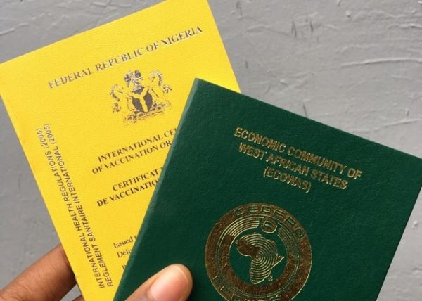 yellow fever card and Nigerian international passport held in the hand 