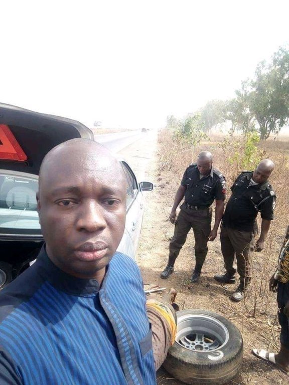 policemen help man fix car