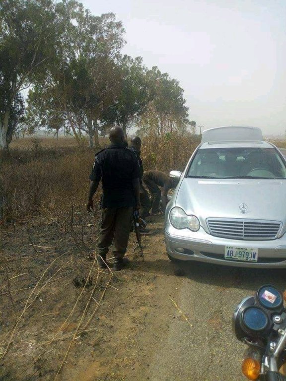 policemen help man fix car