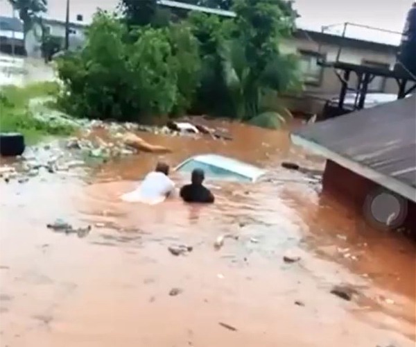 residents of Erediauwa axis of Benin-city are seen trying to pullout a submerged car from a scene of flooding.