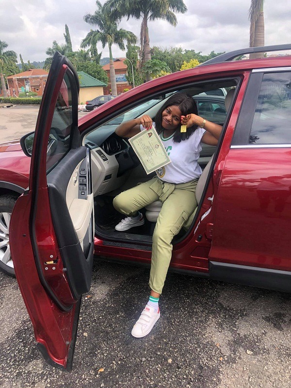 female corper posing with her SUV
