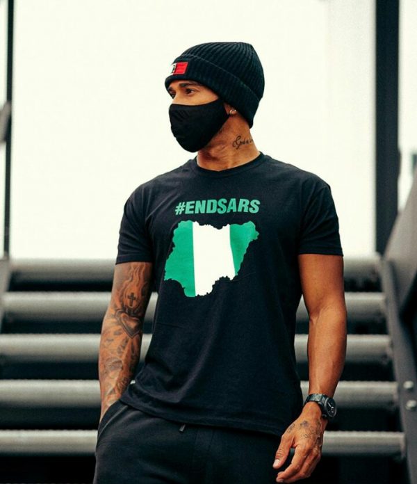 lewis hamilton putting on his endsars t-shirt